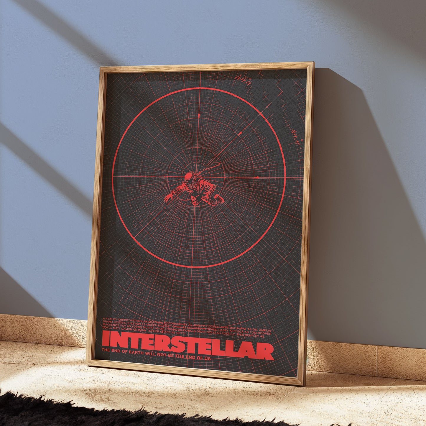 Framed 'Interstellar' movie poster with red design on a wall.