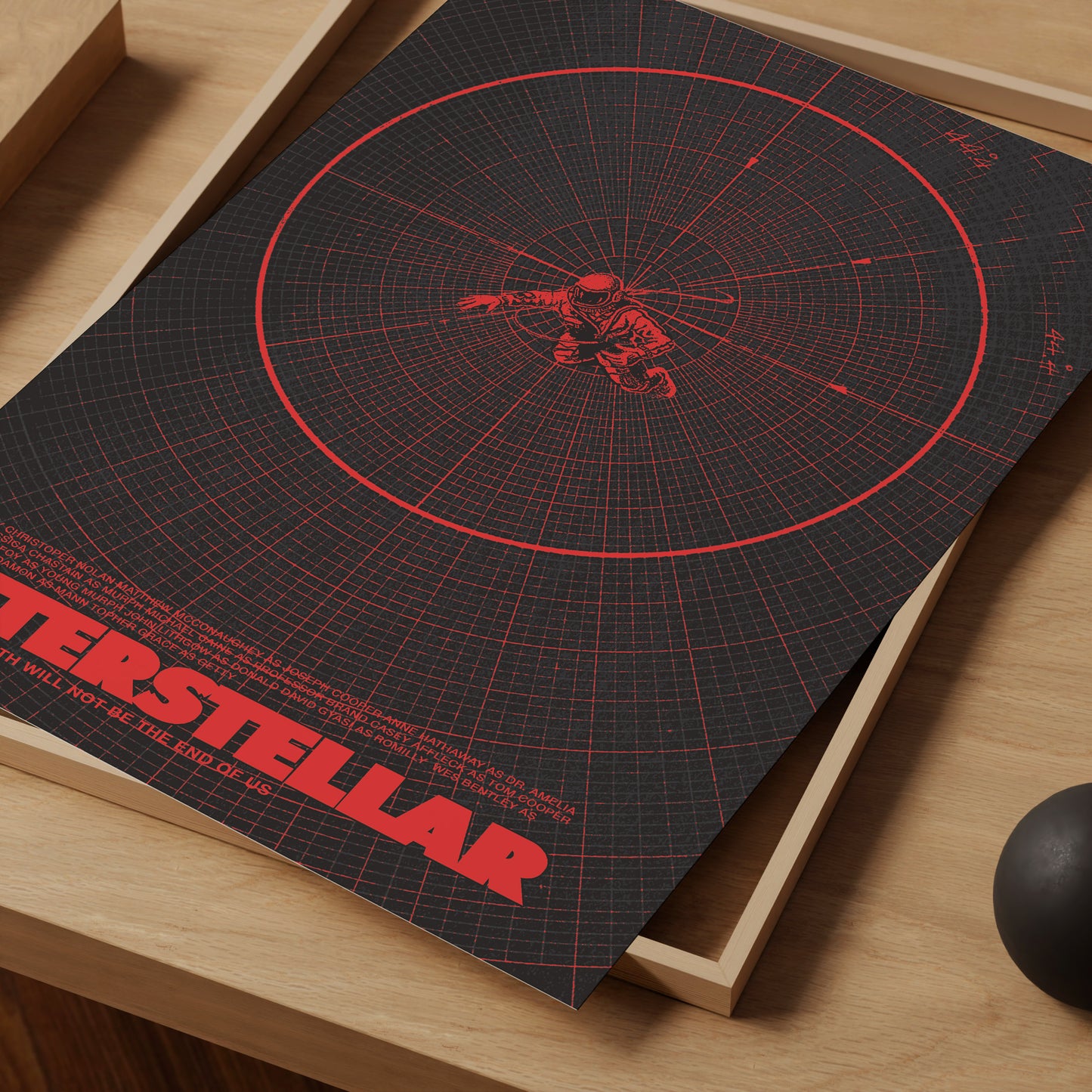 Poster of 'Interstellar' movie with red design on a wooden surface