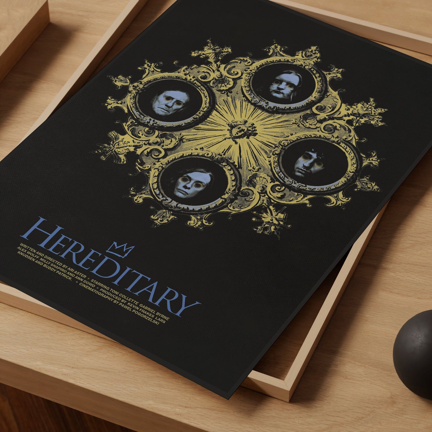 Movie poster for 'Hereditary' with decorative design on a wooden surface