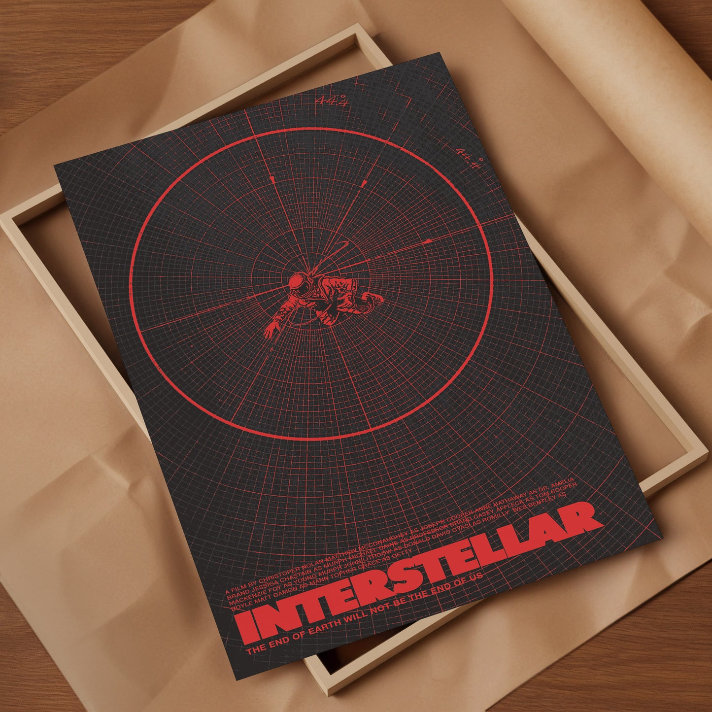 Poster of 'Interstellar' with red design on a dark background, placed in an open box.