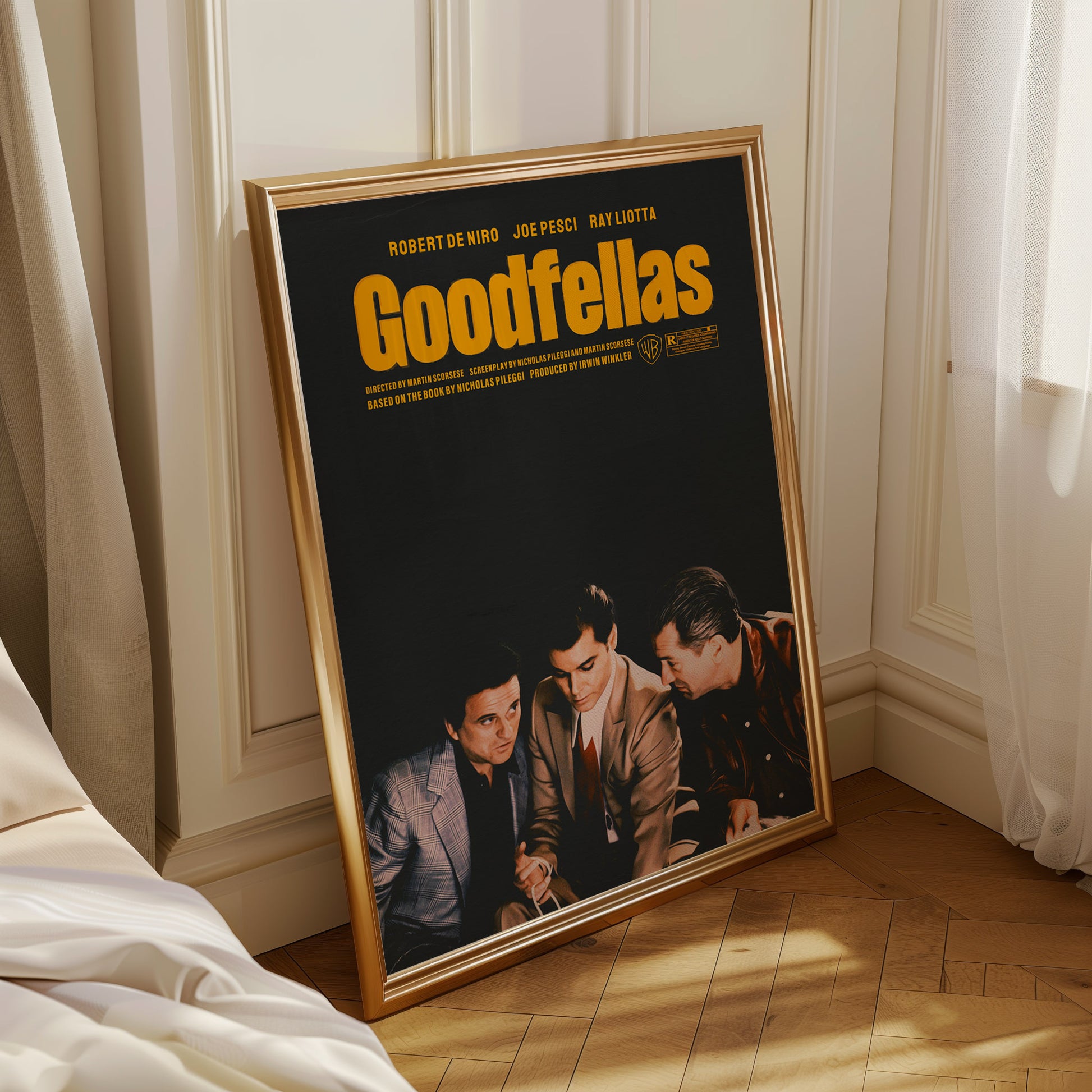 Framed 'Goodfellas' movie poster on a wooden floor with curtains in the background